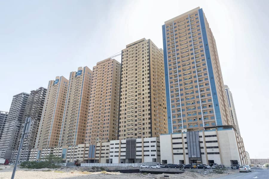 Spacious two bedroom hall apartment with covered car parking available for rent in Paradise Lake Towers Emirates City Ajman. . .