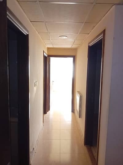 For annual rent in Ajman, two rooms, a hall, a kitchen and a bathroom, a building without plumbing in Al Rawda 2, payment facilities at a price of 22,
