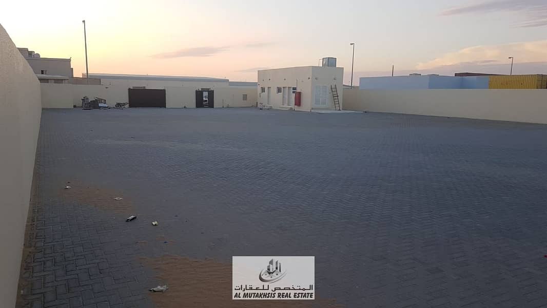 Industrial land for rent in Emirates Industrial City, Al Saja’a, area of ​​19,000 square feet, high electrical power, interlock floor, 2 offices, and on an asphalt street.