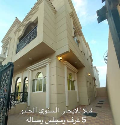 Villa for rent in Ajman, Al Helio area, 5 rooms, a sitting room, a hall, a kitchen, and a maids room with air conditioners. 85 thousand dirhams are required