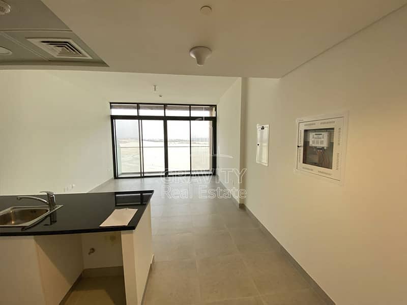 5 soho-square-saadiyat-living-room-view-from-back-and-balcony-and-open-kitchen. jpg