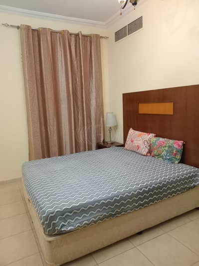 1 Bedroom Apartment for Rent in Al Nuaimiya, Ajman - BEDROOM WITH SIDE TABLE. jpeg