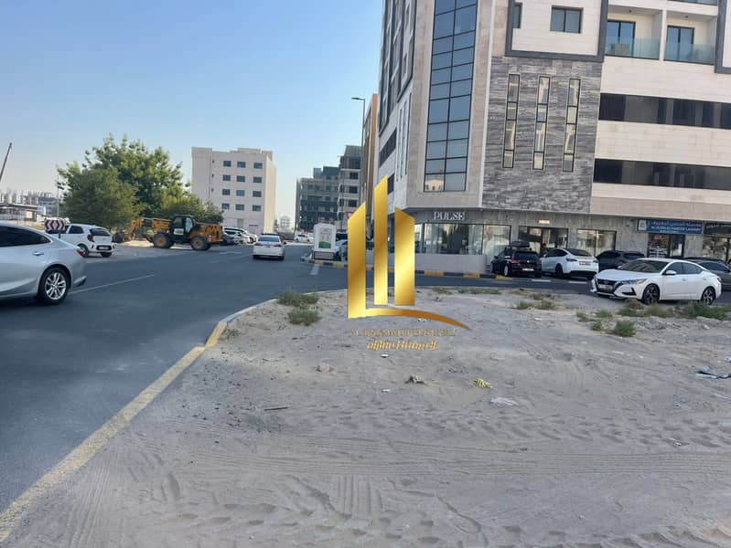 For sale, commercial corner land overlooking the garden in Sharjah, Al