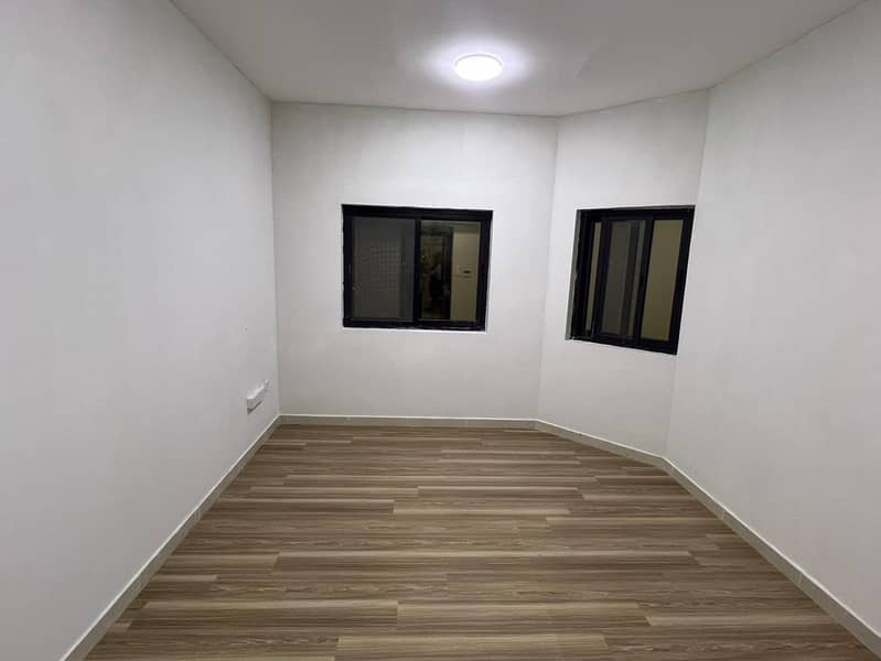 Two-bedroom apartment with hall for annual rent in Al Jurf 3, behind the Chinese Market, near Festival Ajman, 2 bathrooms, balcony, central AC, mainte