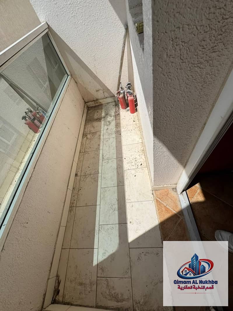 Second Tenant | Balcony with open view – Spacious 1-bedroom apartment with a living room in Al Butina, Sharjah, featuring central AC and central gas .