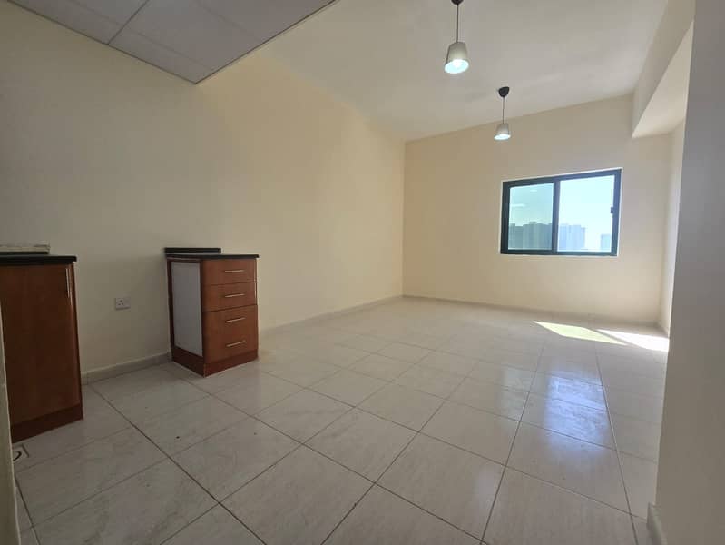 A studio apartment is available for annual rent in Al Rashidiya, Ajman. It boasts a prime location close to all essential services, including schools,