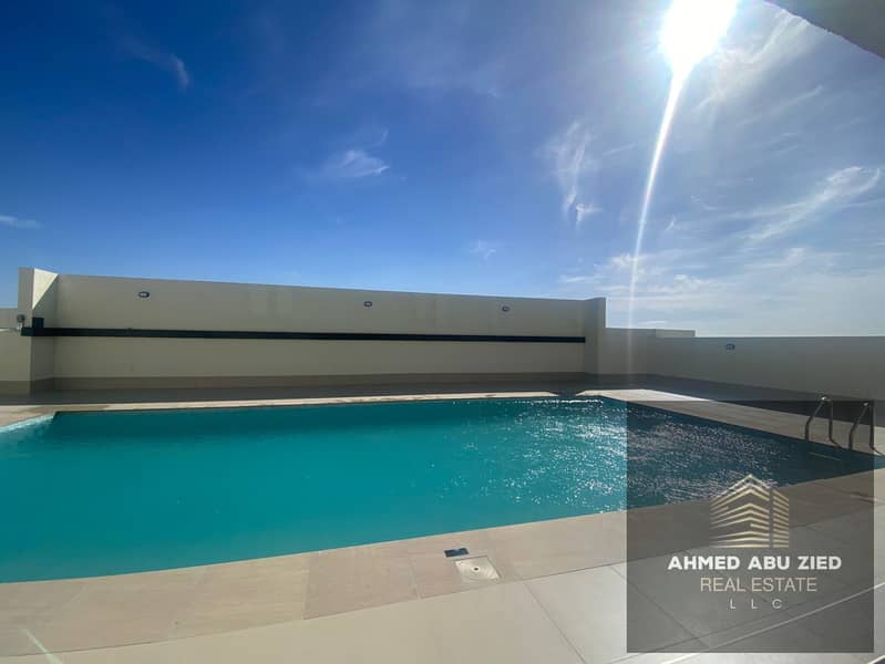 Two master bedrooms and a living room for annual rent in Emirates City, prime location with swimming pool, gym, full services and free parking