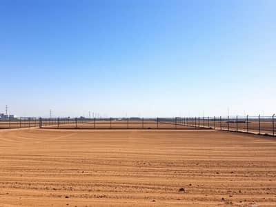 ارض استخدام متعدد للبيع في الجرف، عجمان - A_serene_empty_industrial_plot_featuring_bare_land_with_a_clear_blue_sky_above. _The_plot_is_surrounded_by_a_simple_fence_with_no_buildings_or_machinery_present. _The_ground_is_flat_and_covered_in_brown_earth_suggestin. jpeg ارض استخدام متعدد للبيع في الجرف، عجمان - A_serene_empty_industrial_plot_featuring_bare_land_with_a_clear_blue_sky_above. _The_plot_is_surrounded_by_a_simple_fence_with_no_buildings_or_machinery_present. _The_ground_is_flat_and_covered_in_brown_earth_suggestin. jpeg
