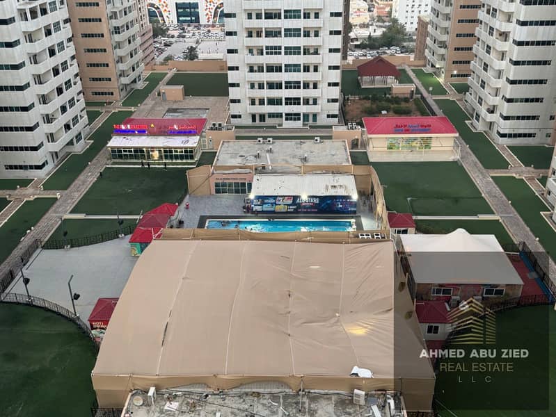 Spacious 2-bedroom apartment for annual rent in Ajman One Towers, Al Rashidiya 3. Features open balcony, 3 baths, pool, garden, storage, and free park