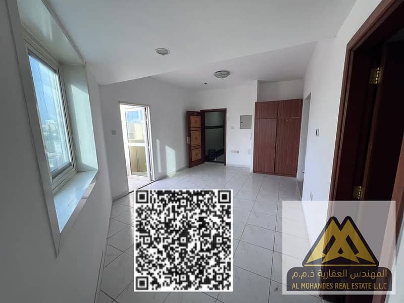 Studio apartment for annual rent in Al Rashidiya 3, Ajman, behind Grand Mall, with a semi-separate kitchen and balcony.