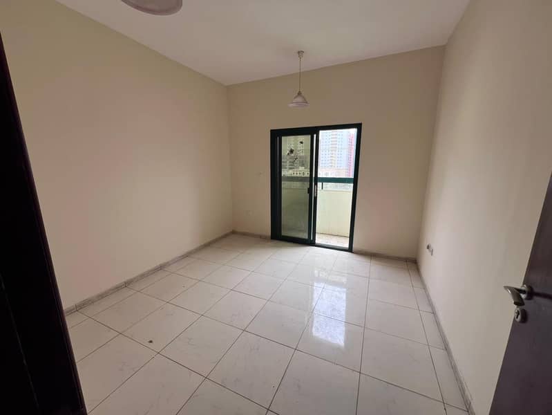 Two-bedroom apartment for annual rent in Al Nuaimiya 1, Ajman, near Al Hikma School. It features two bathrooms, a balcony, a separate kitchen,