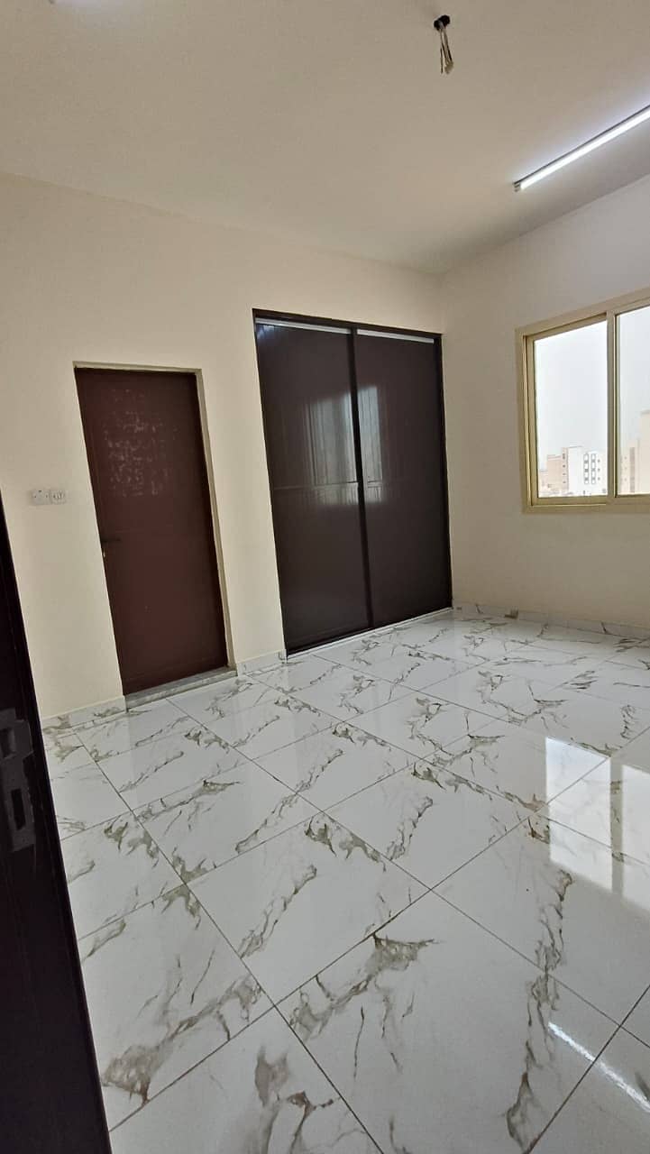 Studio apartment in Al-Aliya, Ajman, with split AC, suitable for families, free maintenance, wardrobe, and separate kitchen.