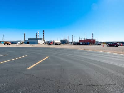 Industrial Land for Rent in Al Sajaa Industrial, Sharjah - A_construction_site_featuring_a_large_newly_paved_parking_lot_in_the_foreground. _The_area_is_devoid_of_construction_vehicles_showcasing_the_smooth_asphalt_surface. _In_the_background_industrial_buildings_and_smokestac. jpeg Industrial Land for Rent in Al Sajaa Industrial, Sharjah - A_construction_site_featuring_a_large_newly_paved_parking_lot_in_the_foreground. _The_area_is_devoid_of_construction_vehicles_showcasing_the_smooth_asphalt_surface. _In_the_background_industrial_buildings_and_smokestac. jpeg