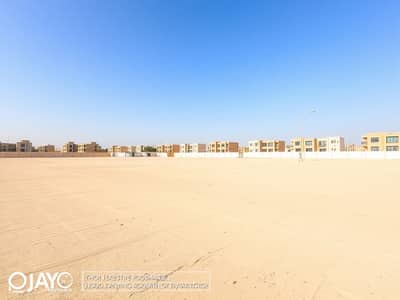 阿尔罗达， 阿治曼 混合用途用地待售 - A_large_empty_residential_plot_in_the_UAE_situated_one_block_from_a_road. _The_scene_features_an_expansive_flat_sandy_terrain_without_trees_or_signs_creating_an_open_unobstructed_view. _The_sky_is_bright_blue_typic (2). jpeg