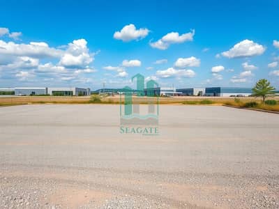 Industrial Land for Sale in Al Sajaa Industrial, Sharjah - A_spacious_industrial_plot_with_a_vast_open_area_ready_for_development. _The_scene_showcases_a_flat_landscape_devoid_of_any_fencing_or_barriers_with_rich_loose_gravel_and_dirt. _Surrounding_the_plot_are_modern_industri. jpeg