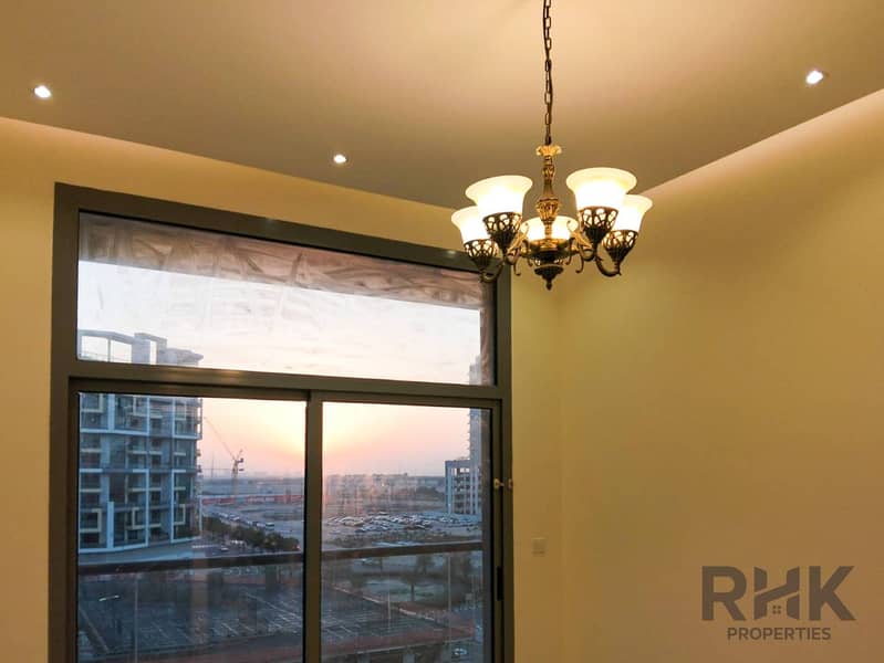 6 Chandelier-lit room with balcony and sunset skyline view in Altia Residence, Dubai Silicon Oasis