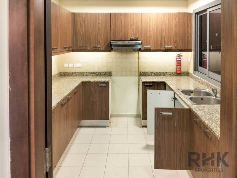 7 Closed kitchen with wooden cabinets and granite countertops in Altia Residence Dubai Silicon Oasis