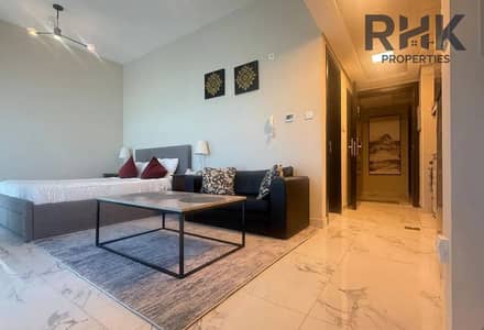 Studio for Rent in Dubai South, Dubai - Furnished studio apartment interior at MAG 5 Boulevard Dubai South with sofa, bed and marble flooring