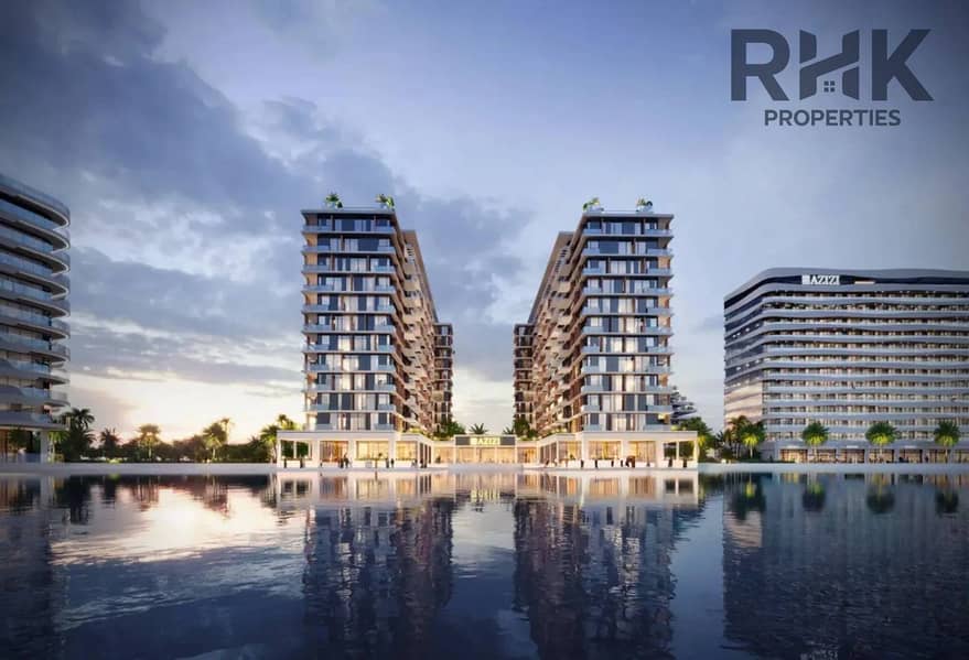12 Azizi Venice apartment towers with retail podium reflected in lagoon at twilight