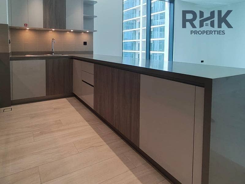 6 Open-plan fitted kitchen with breakfast bar island in Crest Grande apartment Dubai