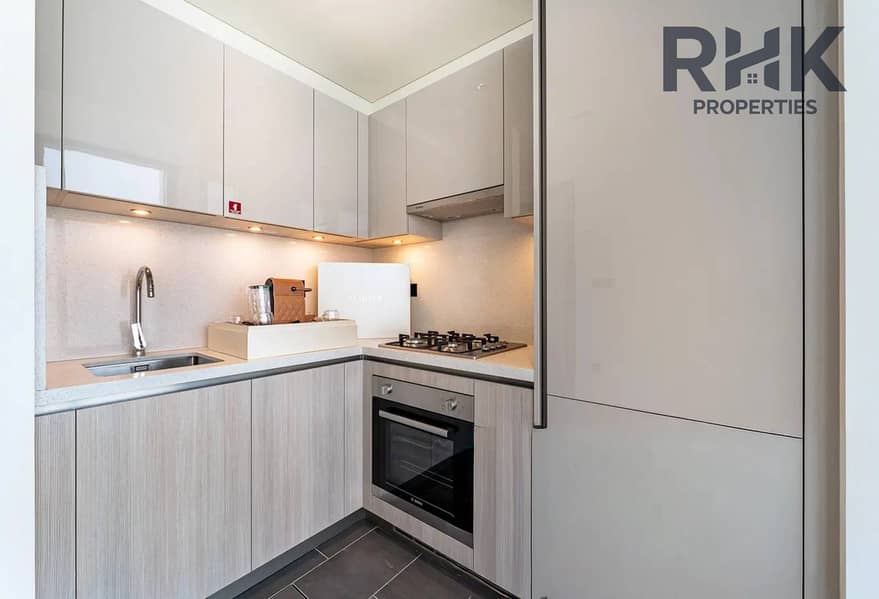 9 Living room with balcony access and open kitchen, Sobha Hartland apartment for rent Dubai