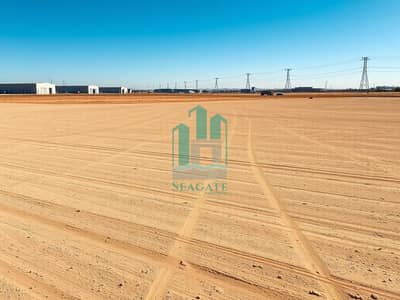 ارض صناعية للبيع في الحمرية، الشارقة - A_large_empty_industrial_land_plot_similar_to_the_reference_image_wide_open_dusty_gravel_lot_with_light_brown_dirt_subtle_tire_tracks_graded_soil_texture_scattered_small_rocks_no_buildings_in_the_foreground_distant_i. jpeg ارض صناعية للبيع في الحمرية، الشارقة - A_large_empty_industrial_land_plot_similar_to_the_reference_image_wide_open_dusty_gravel_lot_with_light_brown_dirt_subtle_tire_tracks_graded_soil_texture_scattered_small_rocks_no_buildings_in_the_foreground_distant_i. jpeg