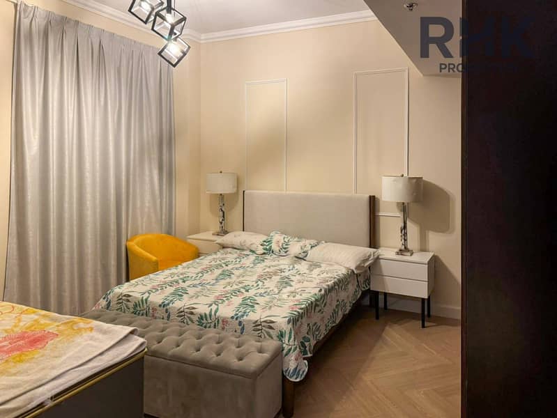 2 Furnished bedroom with upholstered bed, twin nightstands and yellow accent chair in Dubai apartment