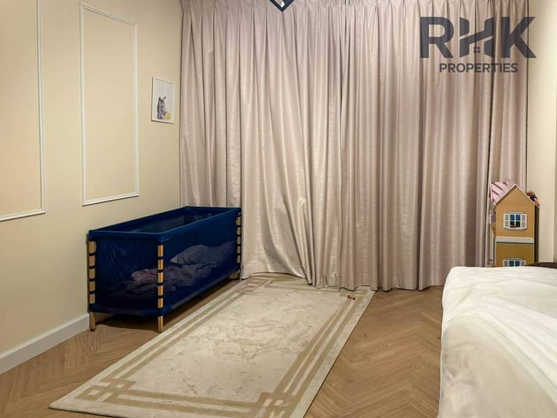 3 Second bedroom with travel cot, area rug and floor-to-ceiling curtains in Dubai residence