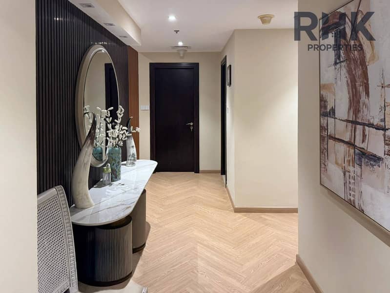 6 Foyer with marble console, round mirror and herringbone wood flooring in Dubai apartment