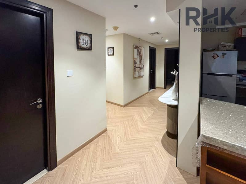 7 Entrance hallway with wood flooring and console table leading to bedrooms in Dubai apartment
