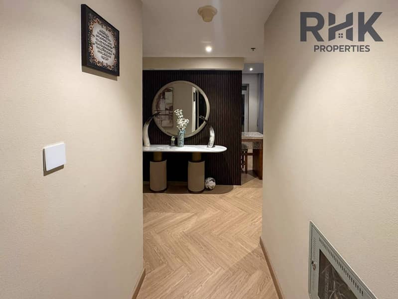8 Hallway with decorative mirror console and herringbone wood flooring in Dubai apartment