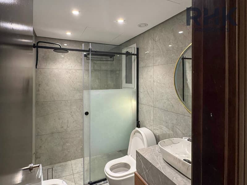 9 Modern bathroom with walk-in rain shower, marble tiling and vessel basin in Dubai apartmen