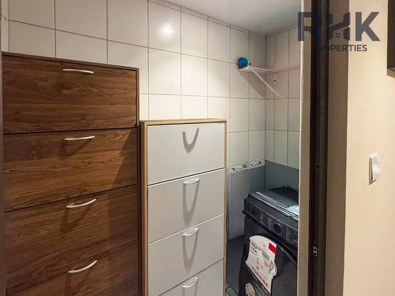 11 Utility room with storage cabinets and washing machine in Dubai apartment