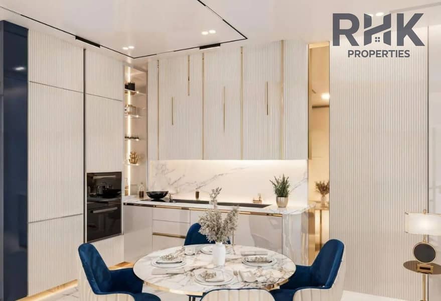 5 Fitted kitchen and dining area in Danube Oasis Dubailand apartment with marble counters and blue chairs
