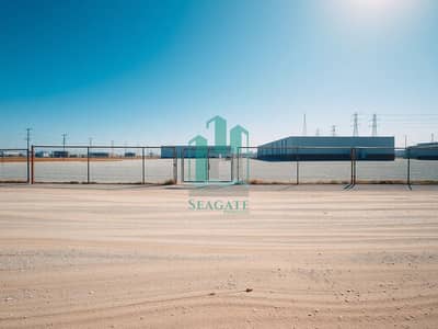 Mixed Use Land para en Venta en Al Jurf, Ajman - An_empty_industrial_lot_warehouse_yard_ground_level_wide_angle_photo_style. _Large_flat_gravel_and_dirt_surface_with_subtle_tire_marks_and_scattered_small_stones_beige_dusty_texture. _Perimeter_chain_link_fence - Copy (2). jpeg Mixed Use Land para en Venta en Al Jurf, Ajman - An_empty_industrial_lot_warehouse_yard_ground_level_wide_angle_photo_style. _Large_flat_gravel_and_dirt_surface_with_subtle_tire_marks_and_scattered_small_stones_beige_dusty_texture. _Perimeter_chain_link_fence - Copy (2). jpeg