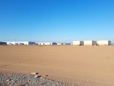 ارض صناعية للبيع في مدينة الإمارات الصناعية، الشارقة - A_vast_empty_industrial_plot_of_land_covered_with_dirt_and_gravel_ready_for_future_construction. _In_the_background_there_are_several_nearby_industrial_buildings_and_warehouses_under_a_clear_blue_sky. _Utility_poles_c - Copy. jpeg ارض صناعية للبيع في مدينة الإمارات الصناعية، الشارقة - A_vast_empty_industrial_plot_of_land_covered_with_dirt_and_gravel_ready_for_future_construction. _In_the_background_there_are_several_nearby_industrial_buildings_and_warehouses_under_a_clear_blue_sky. _Utility_poles_c - Copy. jpeg