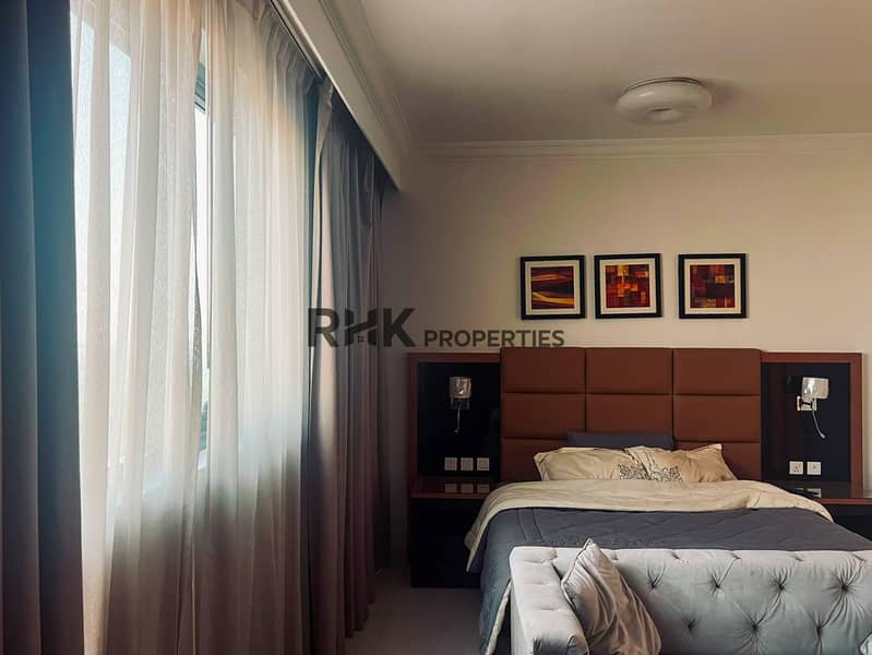 3 Spacious bedroom with floor-to-ceiling curtains and king bed in Dubai furnished apartment