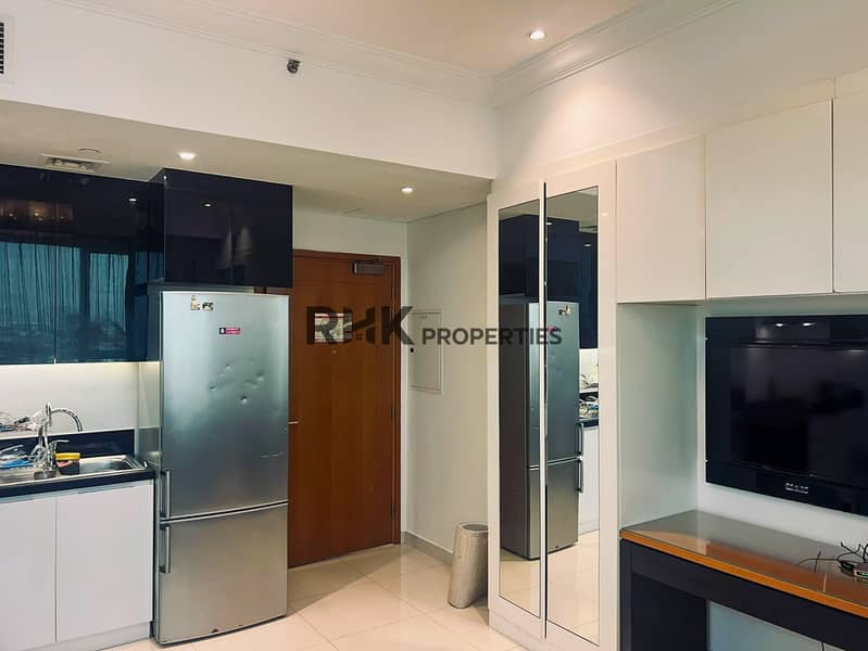 6 Furnished studio apartment kitchen with stainless steel fridge and built-in wardrobe Dubai