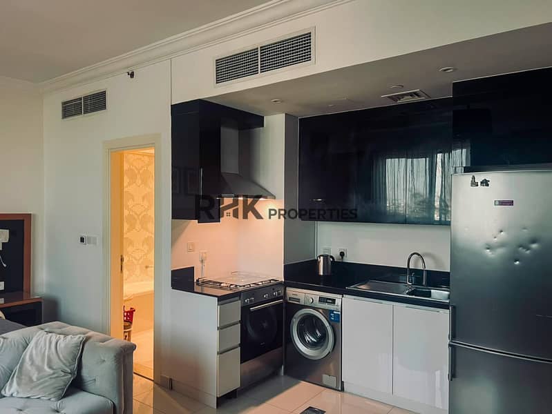8 Open-plan kitchen with gas cooker and washing machine in furnished Dubai apartment