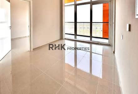 1 Bedroom Apartment for Rent in DAMAC Hills, Dubai - Sunlit bedroom with balcony access and open community views in Dubai apartment