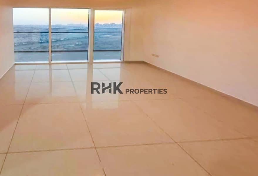 4 Bright unfurnished living room with floor-to-ceiling windows and sunset skyline view