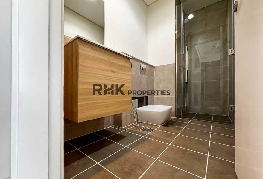 7 Modern bathroom with walk-in glass shower and floating wood vanity in Dubai apartment