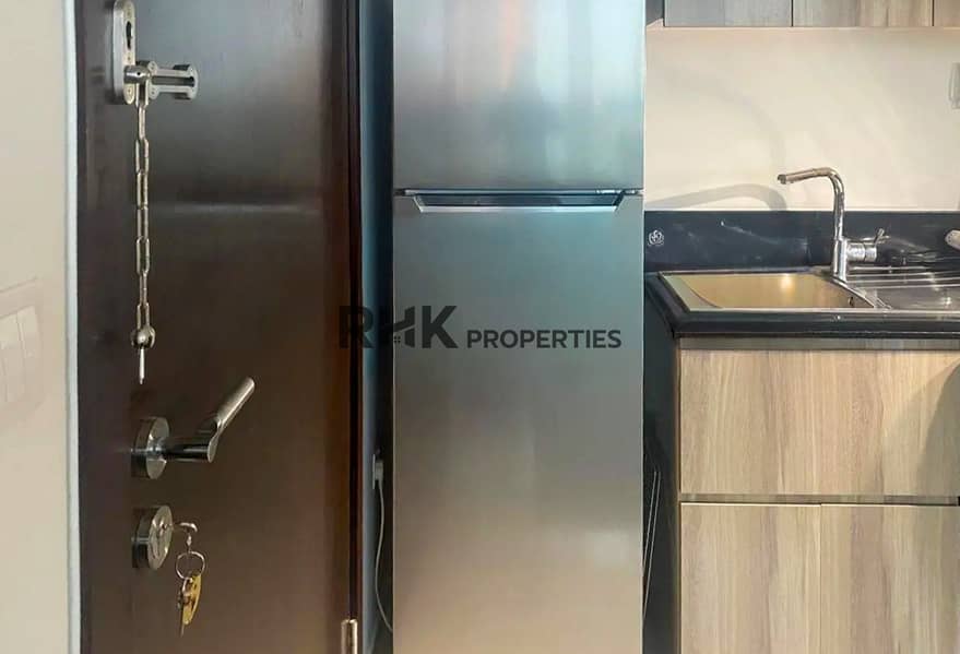 8 Fitted kitchen with stainless steel fridge and secure entrance door in Dubai apartment
