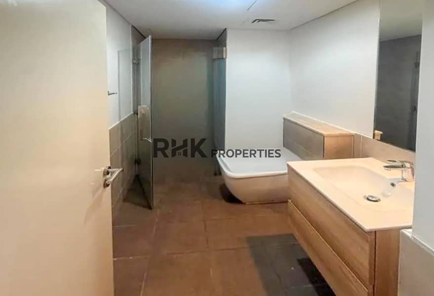 9 En-suite bathroom with bathtub, walk-in shower and wood vanity in Dubai apartment
