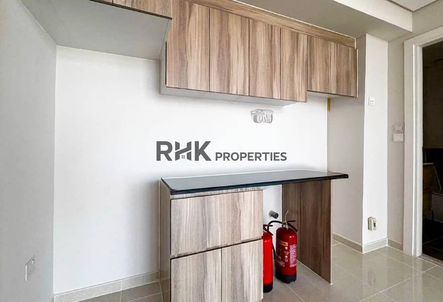 10 Modern kitchen with wood cabinetry and breakfast bar in Dubai apartment