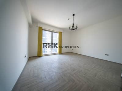 Studio for Sale in Jumeirah Village Circle (JVC), Dubai - Bright unfurnished apartment living area with large window, modern flooring and abundant natural light