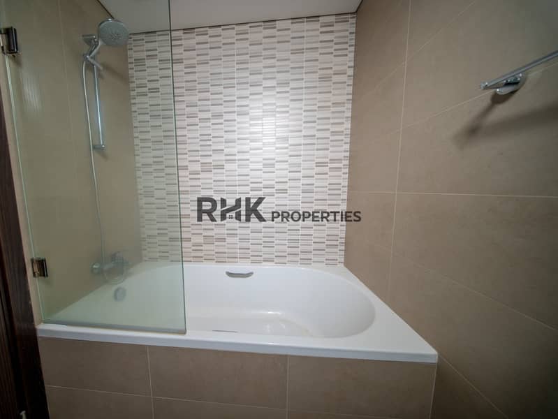5 Contemporary bathroom featuring bathtub with shower, glass partition and stylish tiled walls