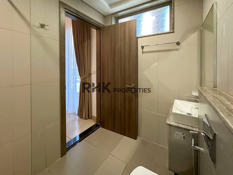 7 Guest bathroom with vessel sink, wall-hung toilet, and natural light window in Jumeirah Village Circle apartment