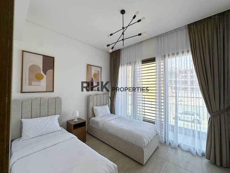 11 Twin bedroom with boucle single beds, sputnik chandelier, and balcony doors in JVC Dubai apartment