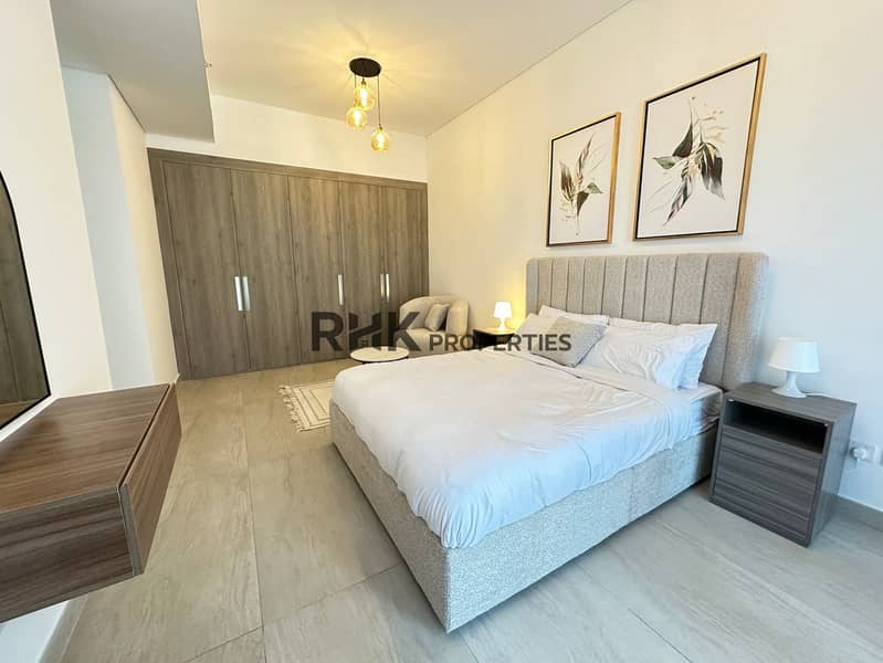 13 Master bedroom with full-length built-in wardrobe, king bed, and botanical wall art in JVC Dubai apartment